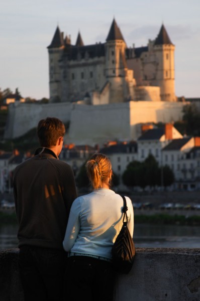 A roumantic couple viewing the Chateau de Saumur along the river
