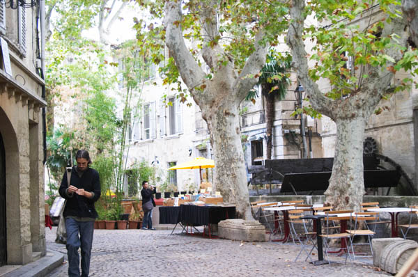 A cobble stone street along a canal with a restaurant