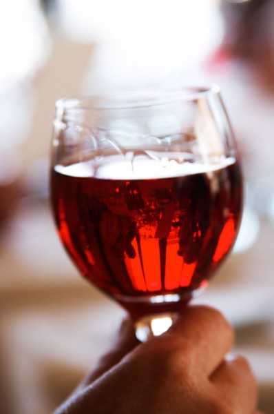 A hand holding a glass of Kir aperitif