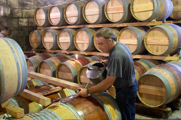 Topping up oak barrels at Chateau Brane Cantenac