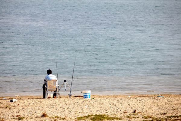 A man on the beach fishing