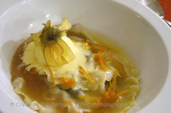 Ravioli with chocolate and vanilla ice cream and physalis fruit in an orange sauce with orange peel zests