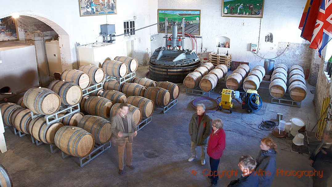 Oak barrels and a press in the cellars of Champagne Marguet