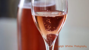 A glass of sparkling rosÃ© wine