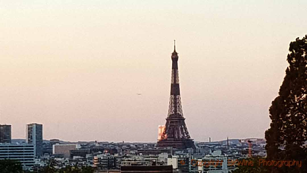 An aircraft in the sky flying past the Eiffel Tower