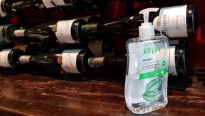 Cleaning hand sanitiser in front of a rack of wine bottles