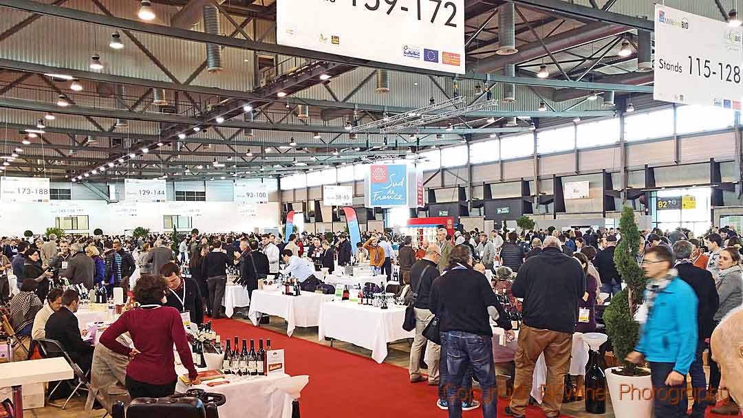 Millesime Bio wine trade fair with visitors and table stands