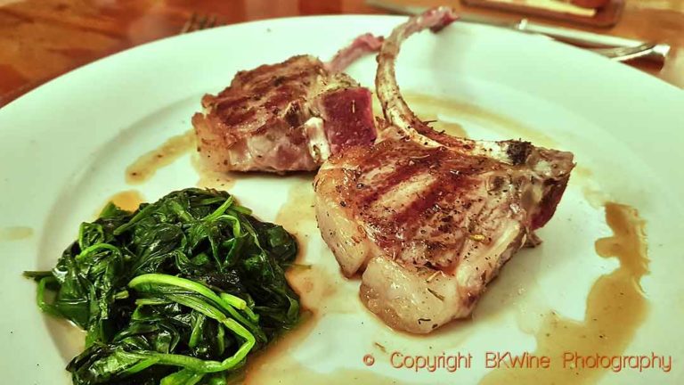 Quickly grilled lamb chops with young leaves of spinach in the jus