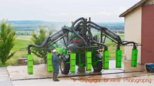 Cleaning with water spray a big tractor equipped for spraying