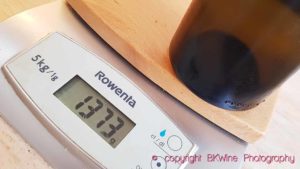 A bottle weighing 1373 grams on a kitchen scale