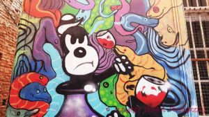 Graffiti / wall painting / mural on a wall in Valparaiso of a cartoon figure holding a wine glass