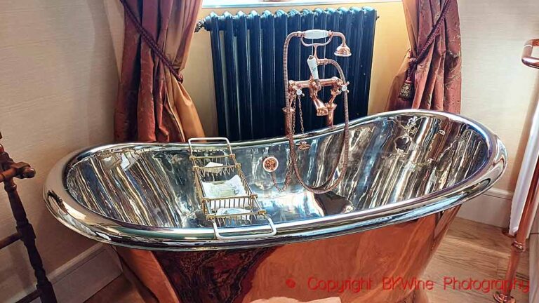 A copper and chrome bathtub in a hotel