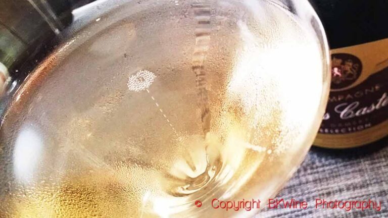 A glass of sparkling wine with bubbles rising to the surface